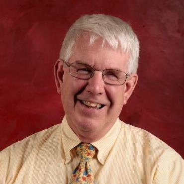 Photo of Dave Madsen in front of red background